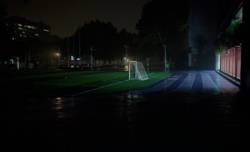 Natopljen fudbalski teren pod tamnim nebom; ilustracija vremenskih uslova, foto Zijian Wang / Unsplash